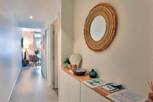 a hallway with a mirror on the wall and a table at Tahiti Beach apartment in Paea