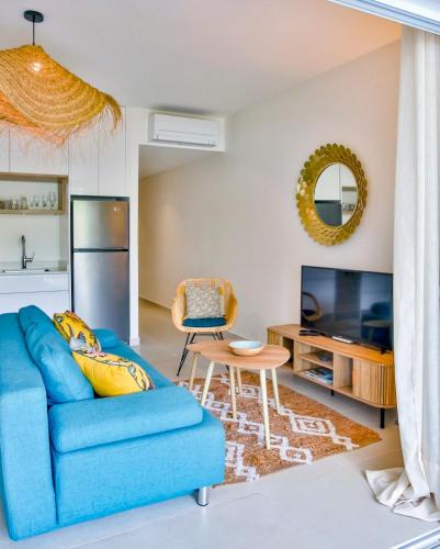 a living room with a blue couch and a table at Tahiti Beach apartment in Paea