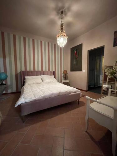 a bedroom with a large bed and a chandelier at Comfortable apartment in Castell'Arquato, 60 m² with garden in CastellʼArquato