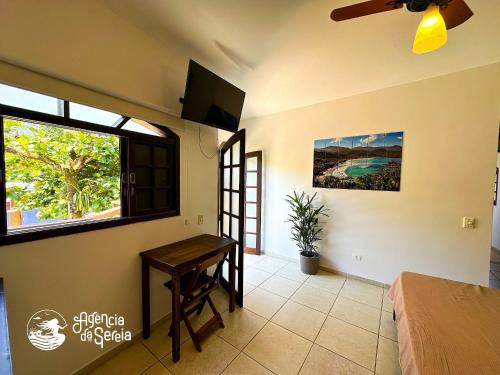a bedroom with a table and a window and a bed at Casa Naturaleza in Ilhabela
