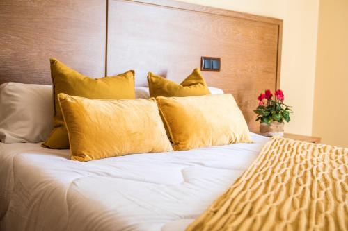 a bedroom with a bed with yellow pillows at Hotel Casa José Díaz in San Agustín de Guadalix