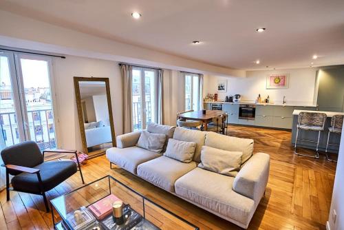 un salon avec un canapé et une cuisine dans l'établissement Magnifique appartement, vue Grand Rex, à Paris