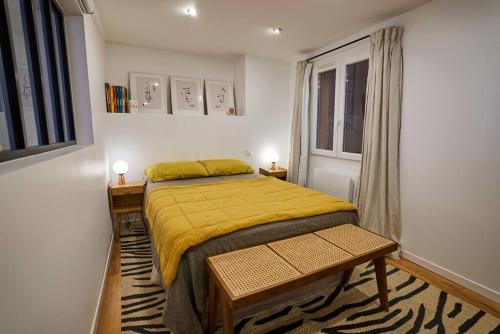une chambre avec un lit jaune et une fenêtre dans l'établissement Magnifique appartement, vue Grand Rex, à Paris