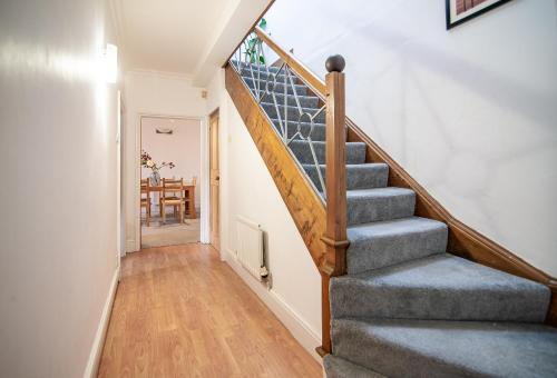 a staircase in a living room with a table at Quaint Centrally Located Getaway in Derby
