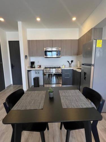 eine Küche mit einem Tisch mit Stühlen und einem Kühlschrank in der Unterkunft Private and secure Downtown apt in Tijuana