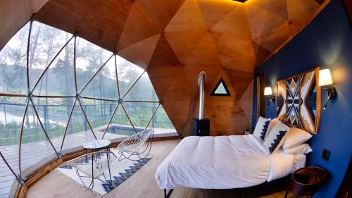 a room with a bed and a large window at Lobo Glamp in Amanalco de Becerra
