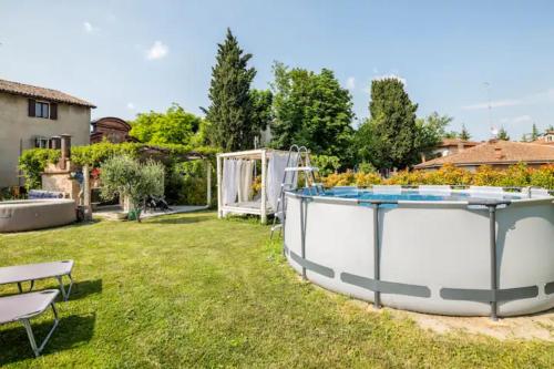 a large pool in a yard with a table and chairs at Villa Dacia in Guiglia