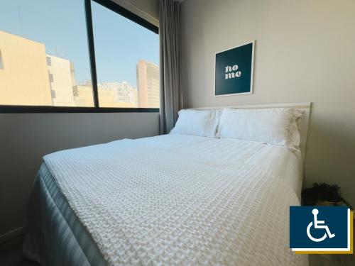 a white bed in a room with a window at Apê Metrô Higienópolis Mackenzie in Sao Paulo