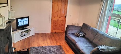 a living room with a couch and a television at Luxurious Self Catering House in Co Donegal in Letterkenny