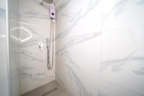 a shower in a bathroom with white marble walls at RODI BLUE apartments in Amoudara Herakliou