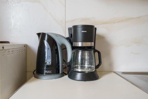 a coffeemaker and a coffee maker on a counter at RODI BLUE apartments in Amoudara Herakliou