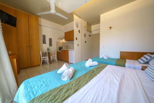 a bedroom with a bed with towels on it at RODI BLUE apartments in Amoudara Herakliou