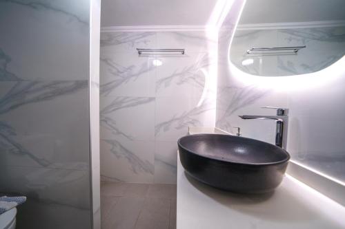 a bathroom with a black sink and a mirror at RODI BLUE apartments in Amoudara Herakliou