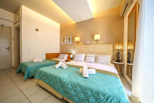 two beds in a hotel room with towels on them at RODI BLUE apartments in Amoudara Herakliou