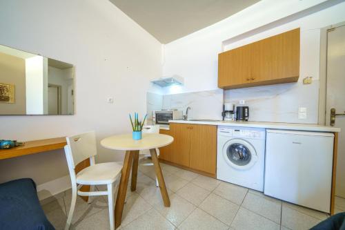 a kitchen with a table and a washing machine at RODI BLUE apartments in Amoudara Herakliou