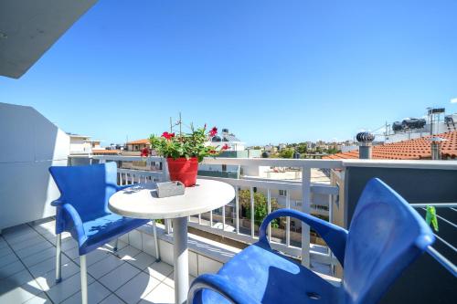 a balcony with blue chairs and a table on a roof at RODI BLUE apartments in Amoudara Herakliou