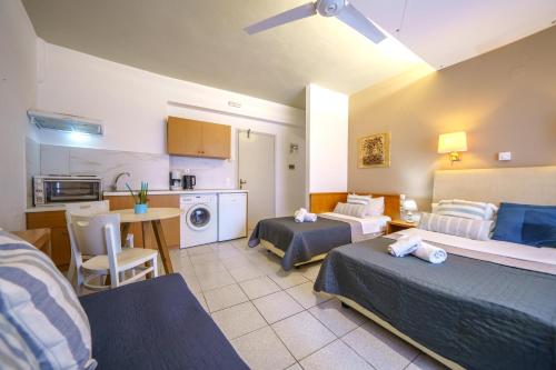 a hotel room with two beds and a kitchen at RODI BLUE apartments in Amoudara Herakliou