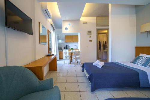 a bedroom with a bed and a living room at RODI BLUE apartments in Amoudara Herakliou