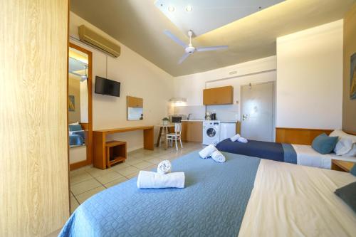 a hotel room with two beds and a kitchen at RODI BLUE apartments in Amoudara Herakliou