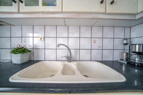 a kitchen counter with a white sink in a kitchen at RODI BLUE apartments in Amoudara Herakliou