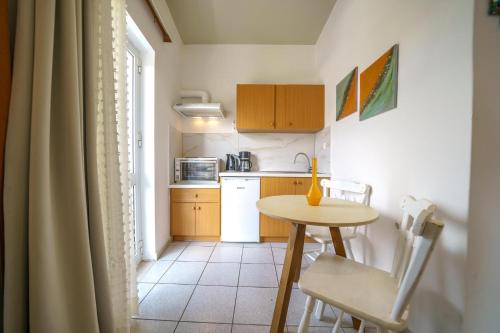 a small kitchen with a table and a table and chairs at RODI BLUE apartments in Amoudara Herakliou