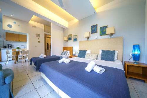 a hotel room with two beds and a kitchen at RODI BLUE apartments in Amoudara Herakliou