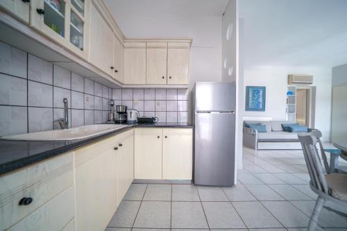 a kitchen with white cabinets and a stainless steel refrigerator at RODI BLUE apartments in Amoudara Herakliou