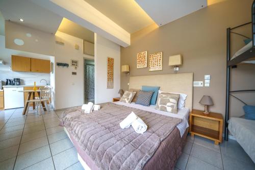 a bedroom with a large bed and a kitchen at RODI BLUE apartments in Amoudara Herakliou