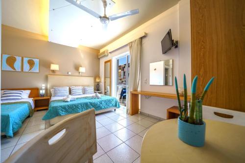 a hotel room with two beds and a table at RODI BLUE apartments in Amoudara Herakliou