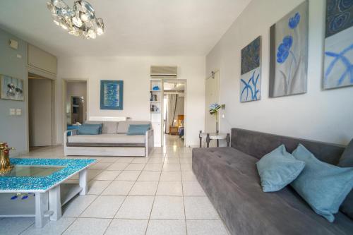a living room with a couch and a table at RODI BLUE apartments in Amoudara Herakliou