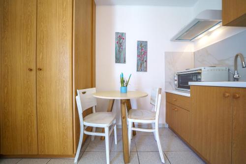 a small kitchen with a small table and chairs at RODI BLUE apartments in Amoudara Herakliou