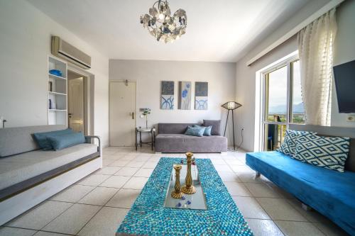 a living room with a couch and a table at RODI BLUE apartments in Amoudara Herakliou