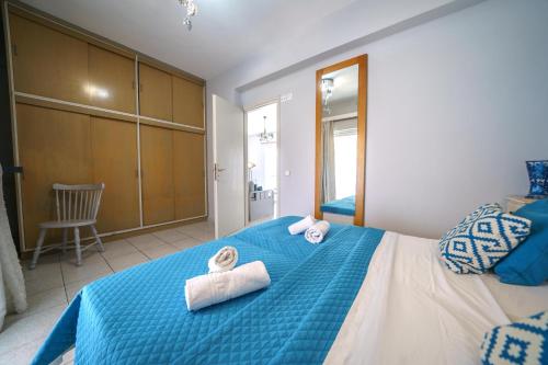 a bedroom with a blue bed with towels on it at RODI BLUE apartments in Amoudara Herakliou