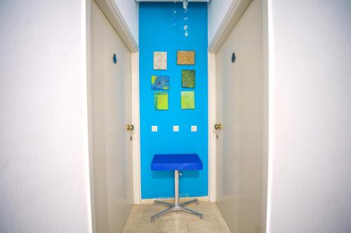 a hallway with a blue wall and a stool at RODI BLUE apartments in Amoudara Herakliou