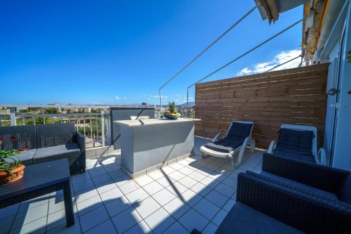 a patio with two chairs and a table on a balcony at RODI BLUE apartments in Amoudara Herakliou