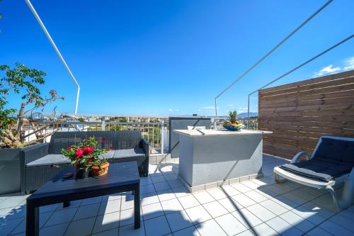 a balcony with two chairs and a table on a roof at RODI BLUE apartments in Amoudara Herakliou