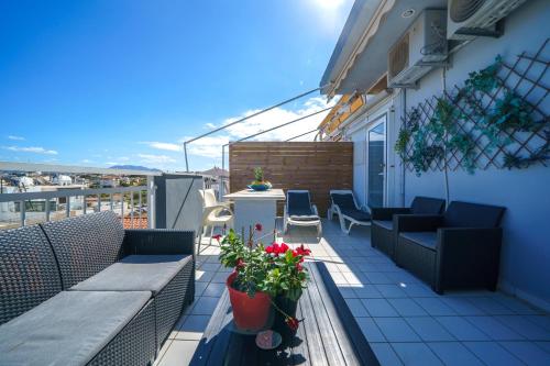 a balcony with furniture and flowers on a building at RODI BLUE apartments in Amoudara Herakliou