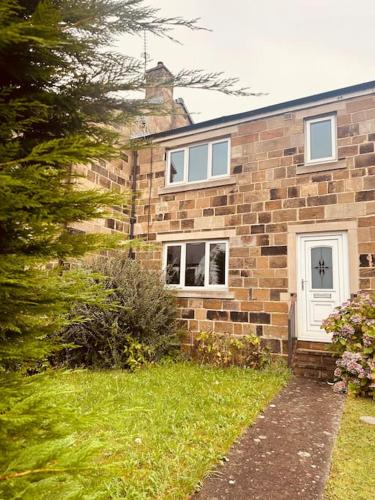 a brick house with a white door and windows at The Jennings in Normanby