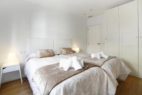 Habitación blanca con cama grande con almohadas en Apartamento La Flamenquita, en Málaga