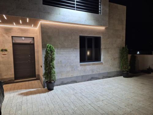 a building with a door and two potted plants at Elite Home in Yerevan