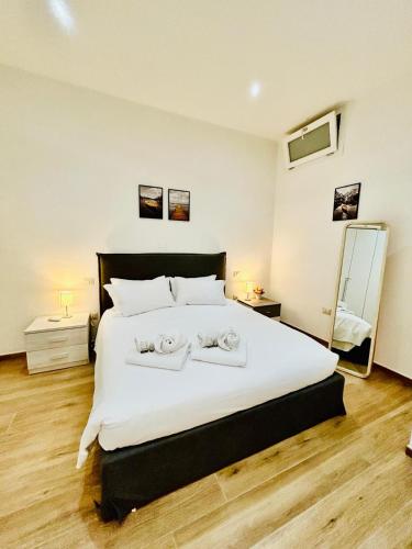 a bedroom with a large bed with two towels on it at SMART SUITES FORLI' in Forlì