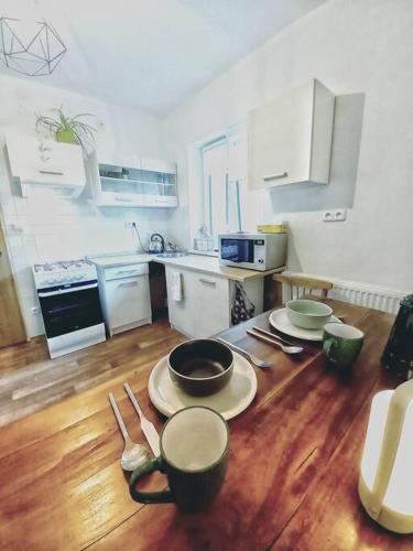 a kitchen with a table with plates and utensils at Zastávka v lázeňském trojúhelníku - apartmán 3 in Šneky