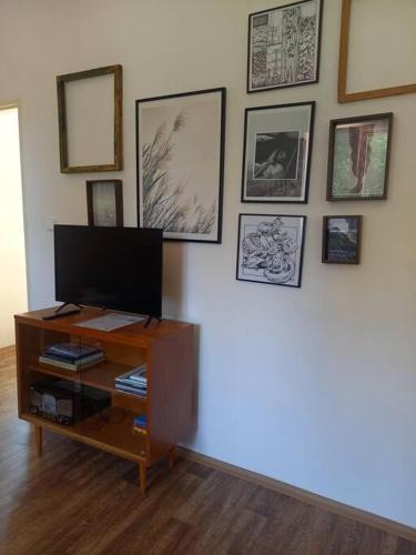a living room with a television on a wall with pictures at Zastávka v lázeňském trojúhelníku - apartmán 3 in Šneky