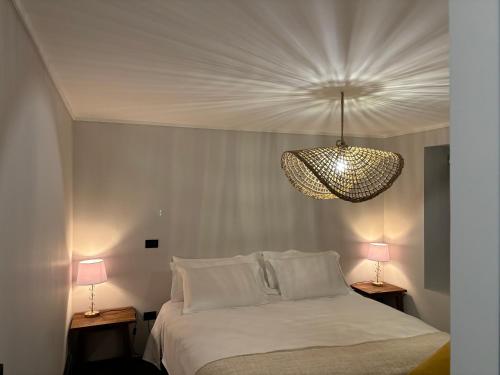 a bedroom with a white bed and two lamps at The Roses in Puerto Varas