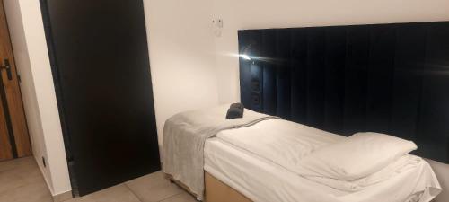 a small bed in a room with a black wall at Poziom -1 in Sandomierz