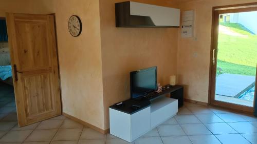 - un salon avec une télévision et une horloge murale dans l'établissement Chalet 2 chambres en Savoie pour 1 à 4 personnes, à Gerbaix