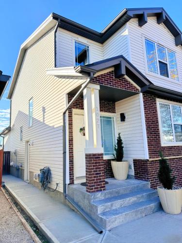 a white house with some stairs in front of it at Modern 2 bedroom suite in Calgary