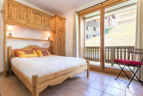 una camera da letto con un letto e una grande finestra di Le Chalet Des Eucherts - Appartement de 6 pièces de 110 m2 pour 10 personne MAE-3194 a Montvalezan
