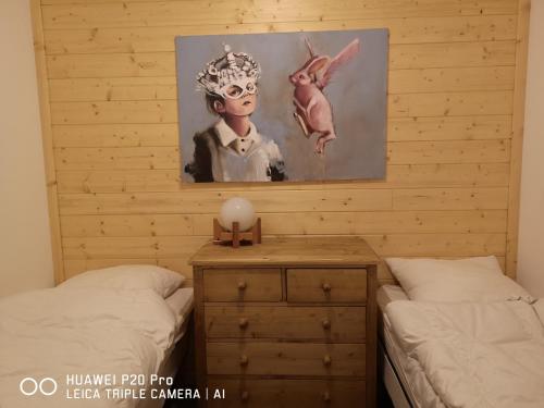 une chambre avec deux lits et un tableau au mur dans l'établissement Charmant appartement Serre-Chevalier, à La Salle Les Alpes
