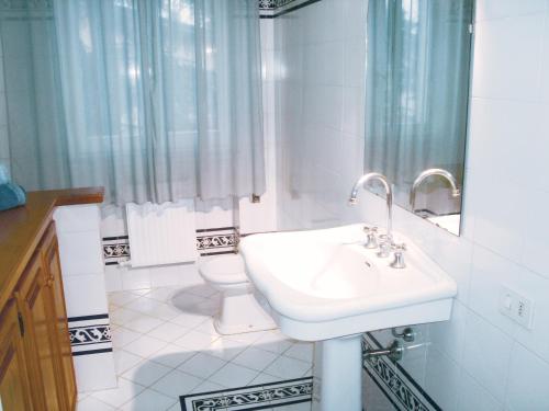 Un baño blanco con lavabo e inodoro. en Residenza Alice - Toscana mare e monti, en Camaiore